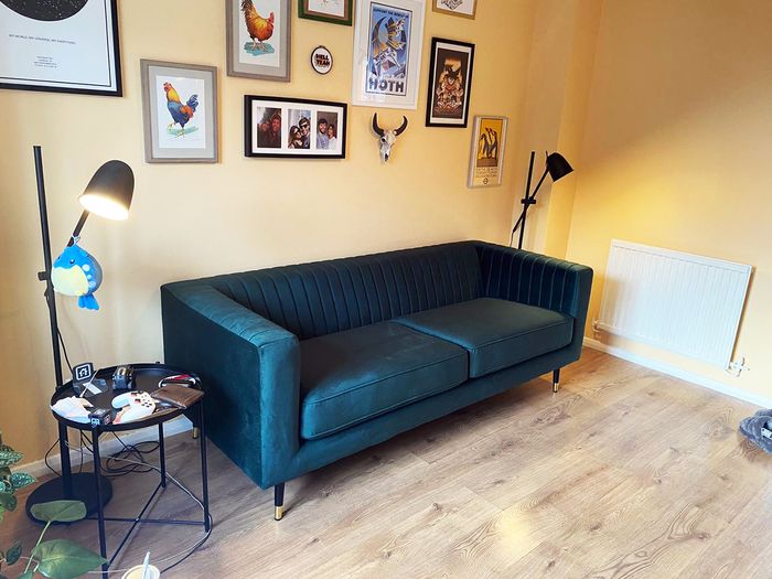 Slender sofa with stitching, legs with golden finish