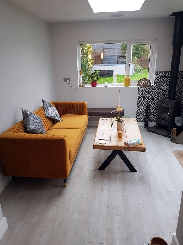 Slender three-person sofa in mustard colour