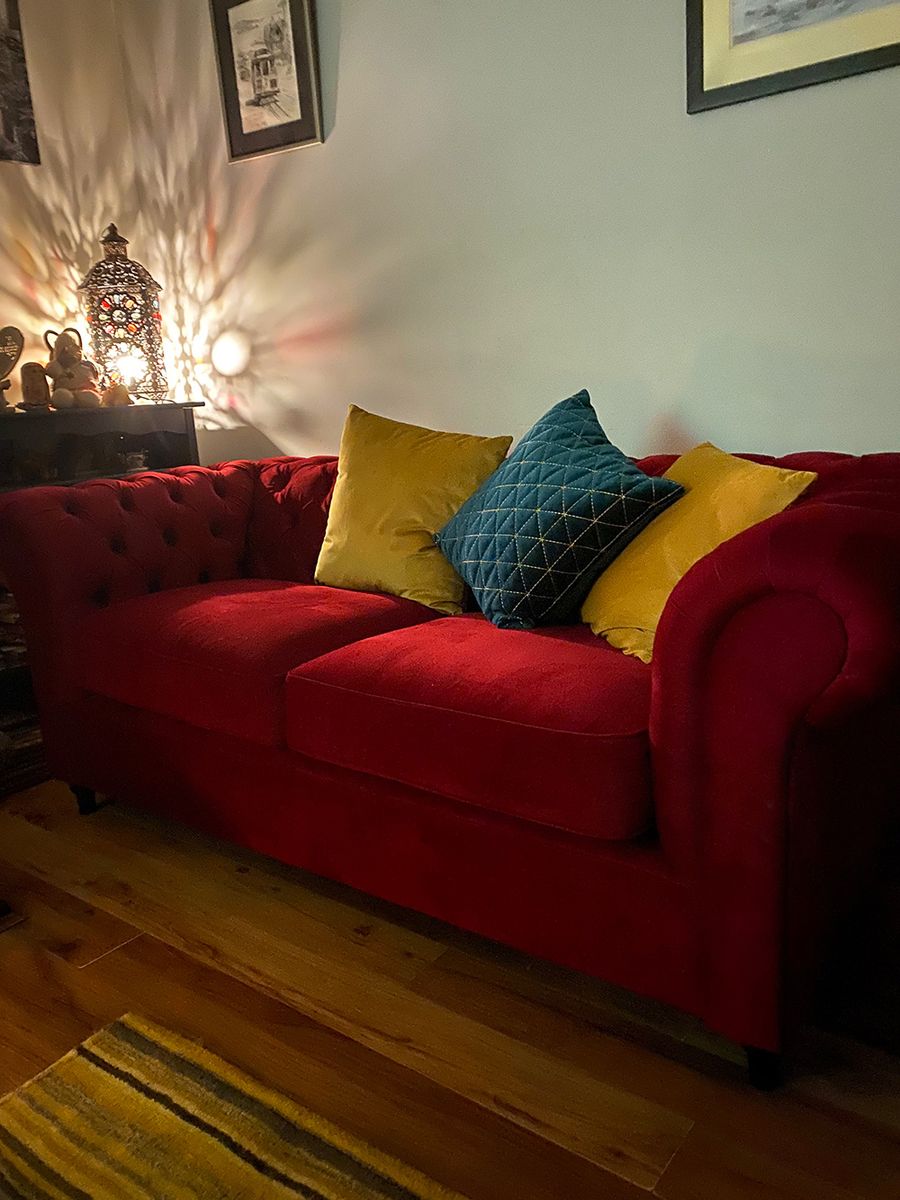 Dark red Chesterfield sofa with additional decorative cushions