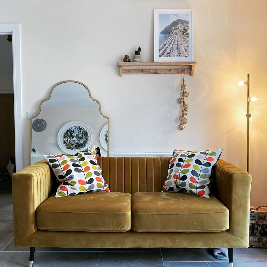 Musztardowa sofa w pokoju ze złotymi dodatkami